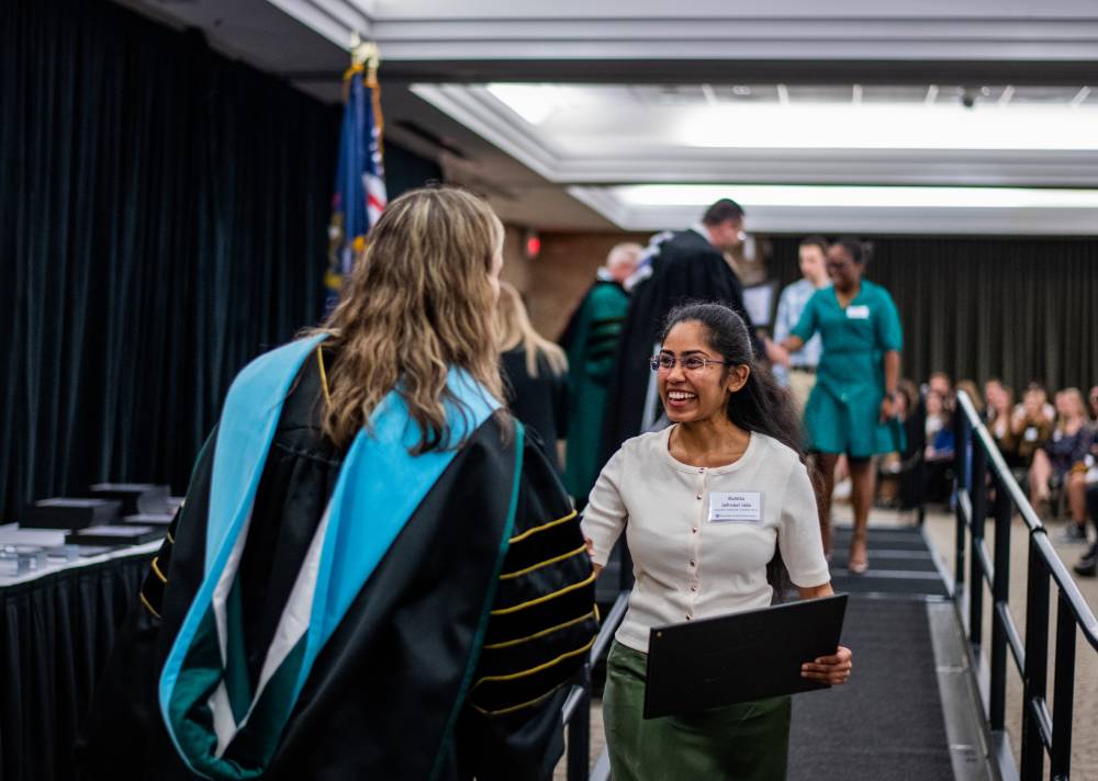 Student shaking hand with faculty 7